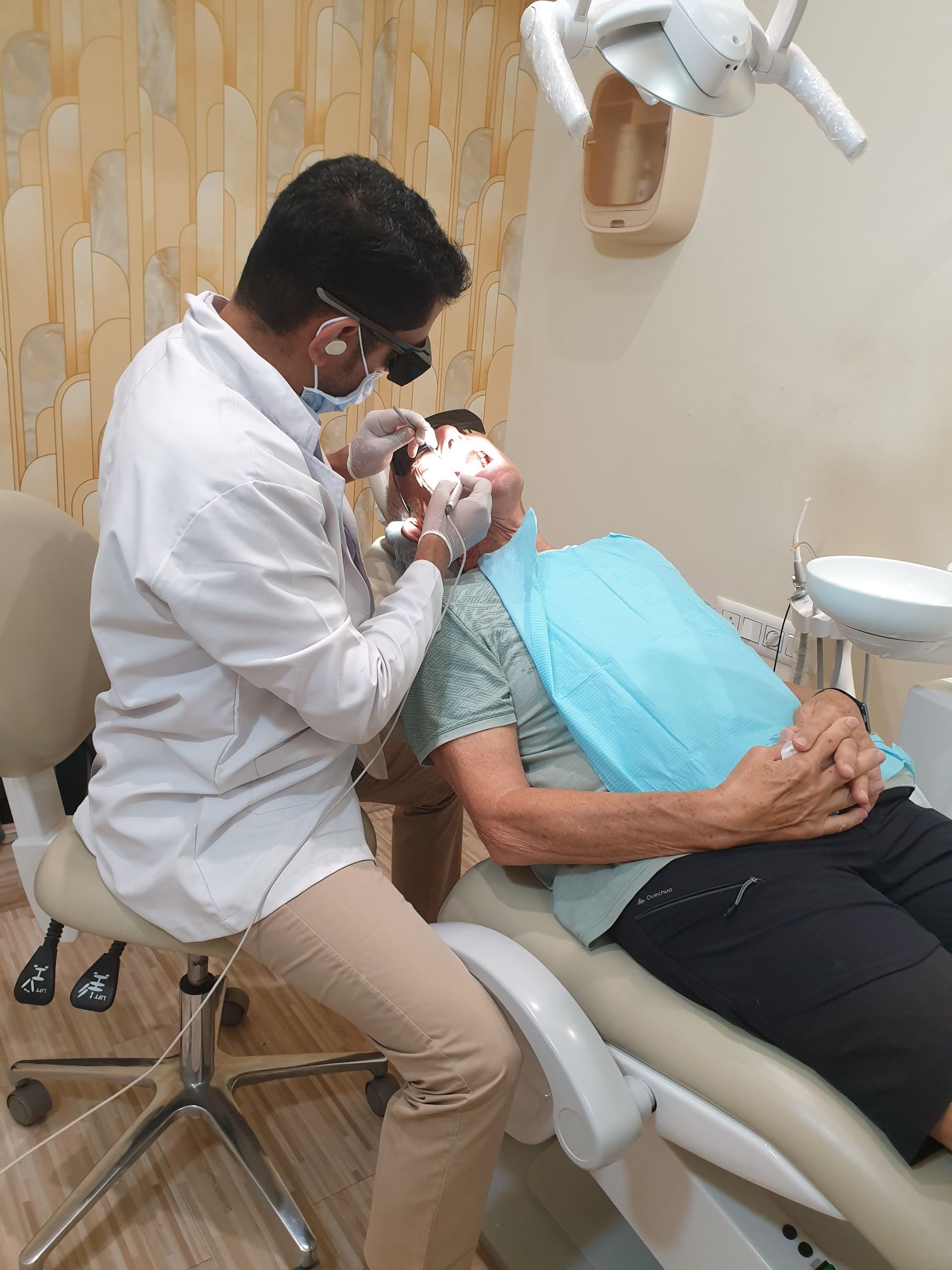 Dentist at Doctor Dental Care performing a soft tissue laser therapy procedure on a patient in the dental chair.