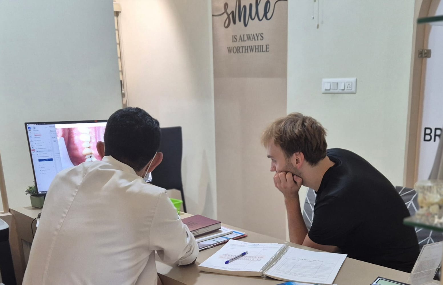 Overseas patient's son discussing dental treatment with a dentist at Dr Rao's Dental Centre in Bangalore